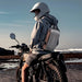 Unisex lightweight crossbody sling bag with built-in anti-theft lock, for travel use, worn by motorcyclist.